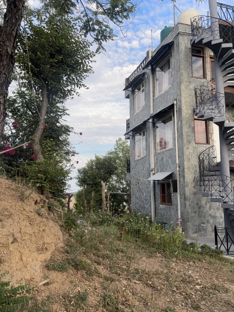 Windows and balconies on the upper floors of the stone building at Lodge at Pong, Dhameta