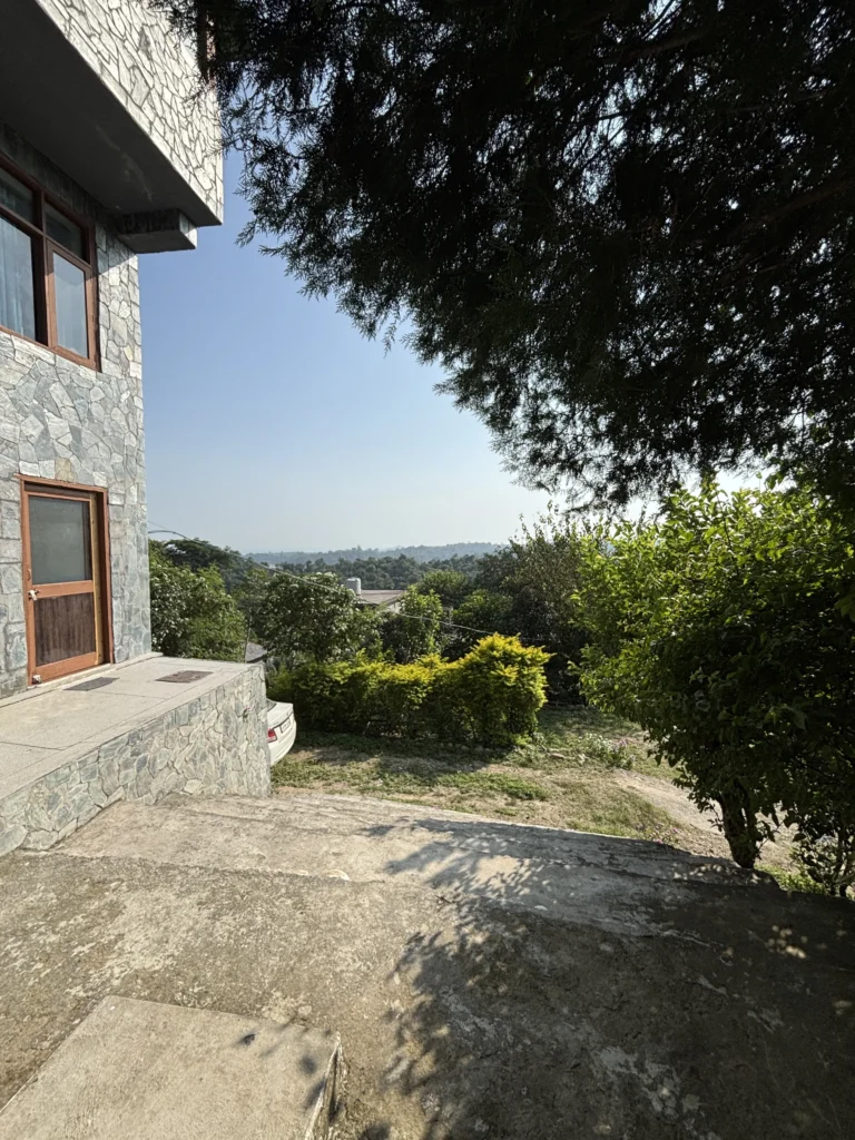 The driveway and ground-floor entrance at Lodge at Pong, Dhameta, with the valley beyond